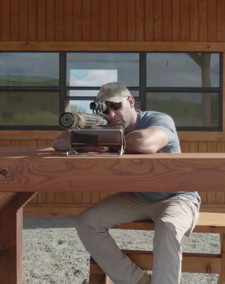 Man in a campo hat shooting a sniper gun